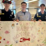 Students holding a Mother's Day banner