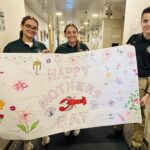 Students holding a Mother's Day banner