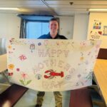 Students holding a Mother's Day banner