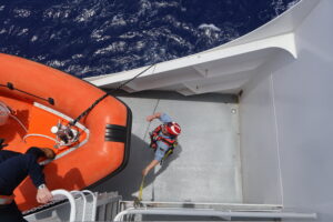 Cadet holding line to stabilize dropping of the boat