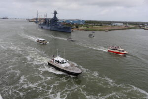 Boats escorting out with USS Texas in the background