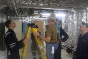 Cadets and instructor working on underside of a hatch