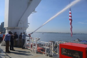 Hoses spraying back aft with flag